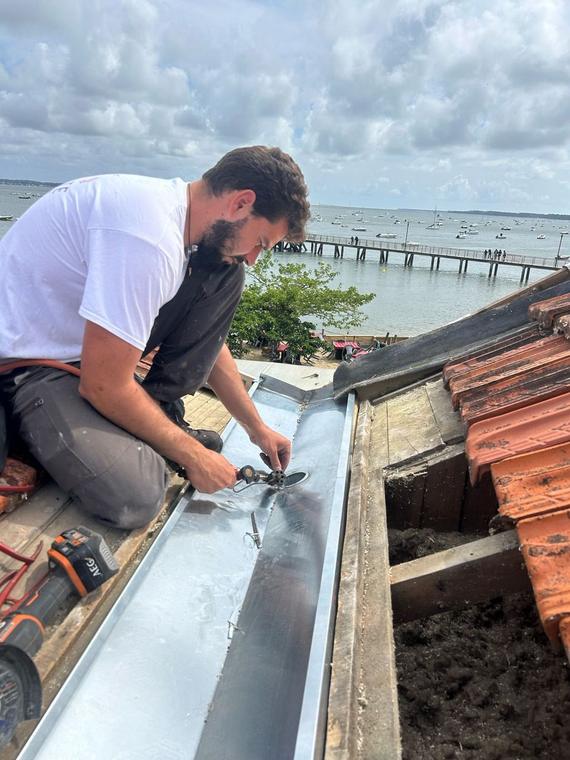 MLA Couvreur au travail sur un chéneau en zinc en Gironde